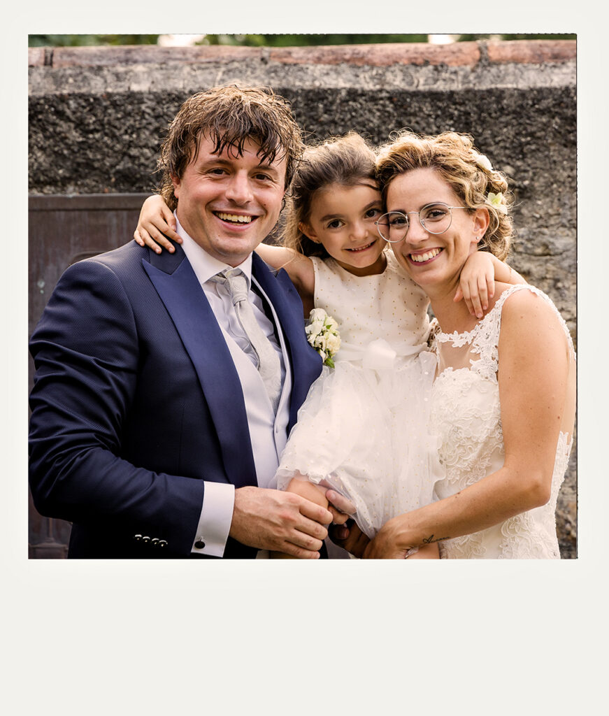 Sposi abbracciati da una bambina
